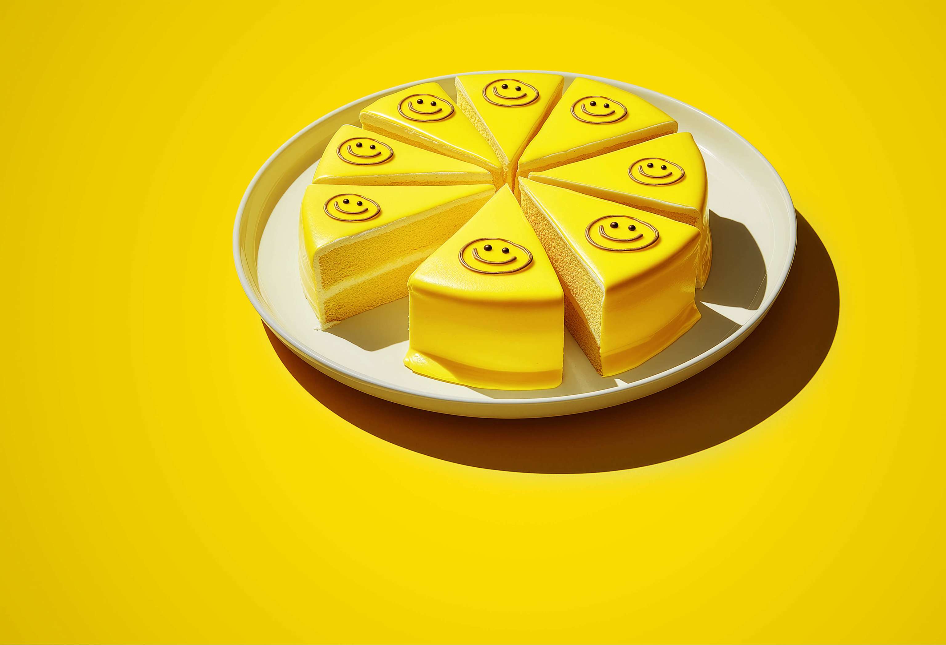 Freunde werben: Begeistere deine Freund:innen & sicher dir eine Prämie! AI image - Gelber Kuchen mit Smileys auf jedem der 8 Stücke