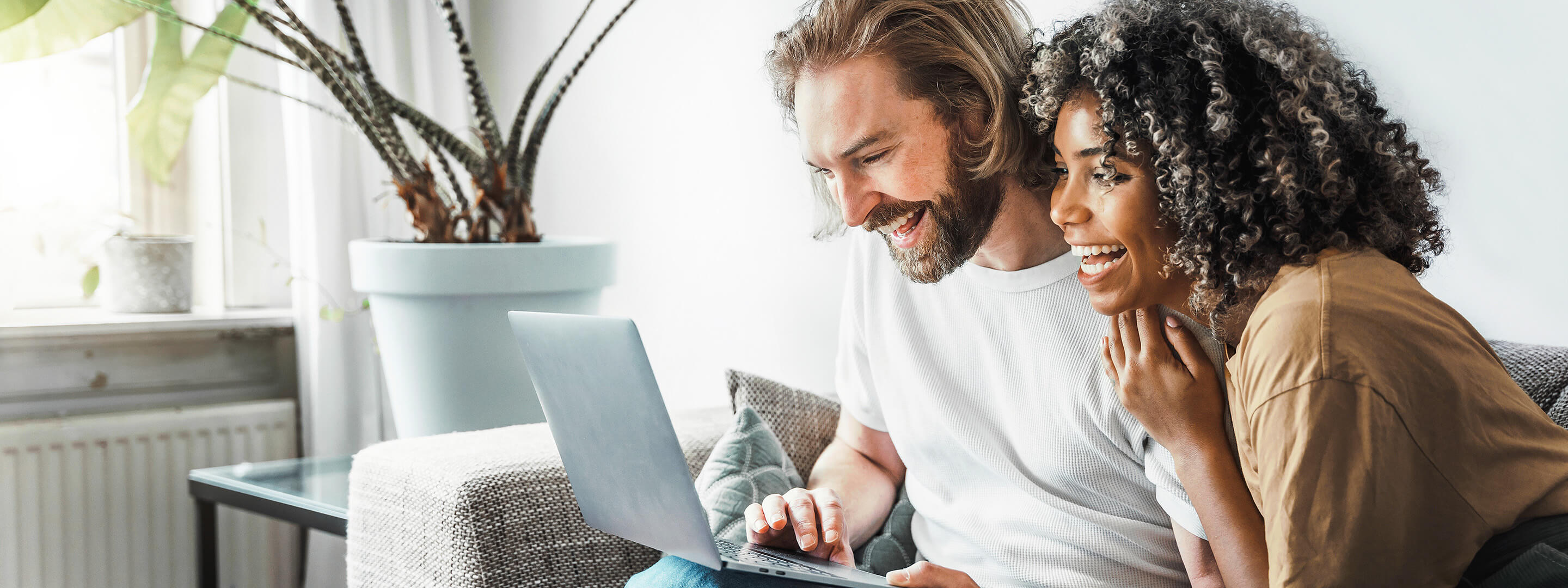 Glückliches Paar auf Sofa mit Laptop