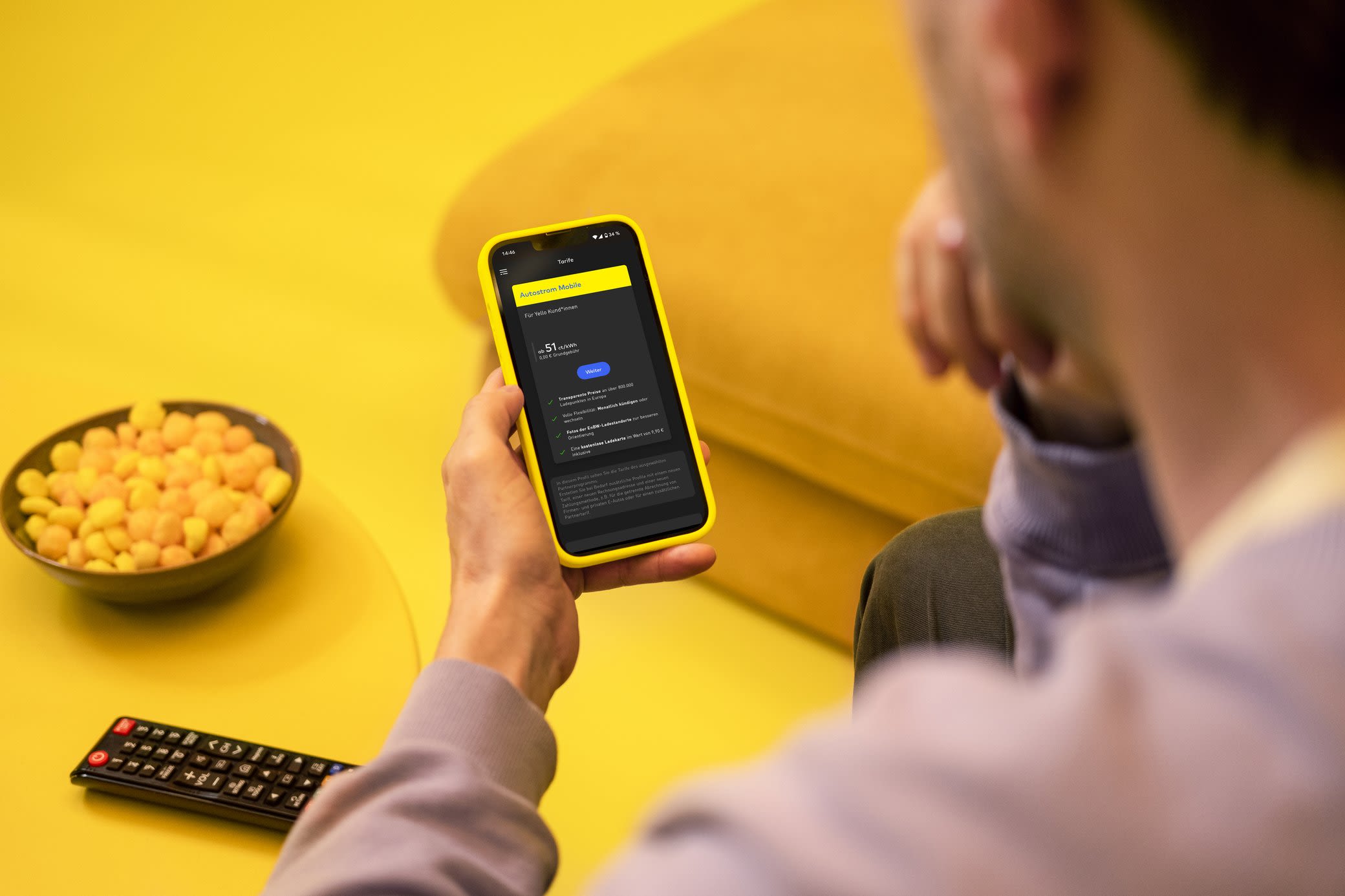 Mit der Yello App hast du deinen flexiblen Stromtarif easy im Blick Mann schaut auf seinem Handy seinen Stromverbrauch in der App an