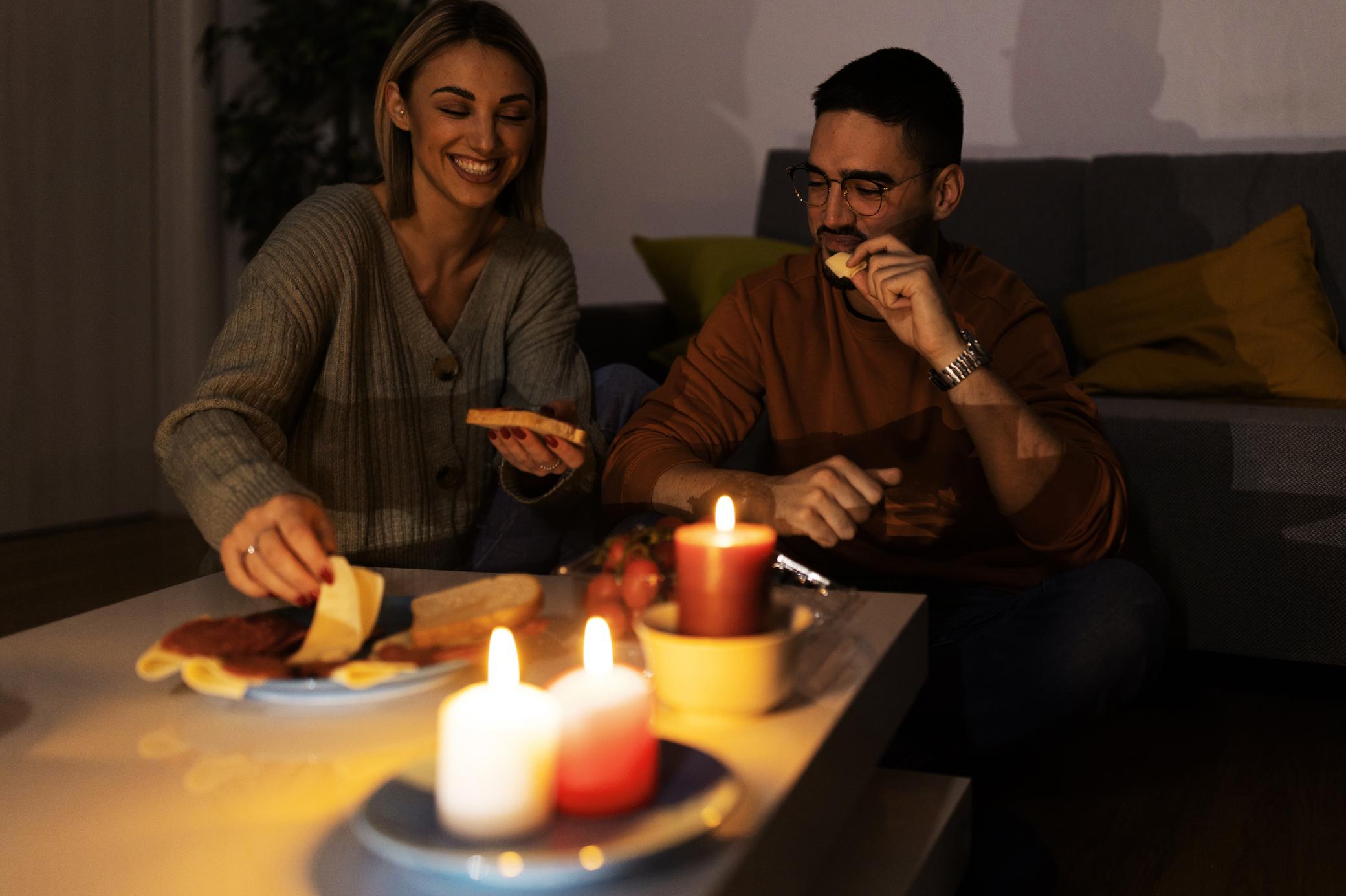 Paar isst bei Kerzenlicht während eines Stromausfalls