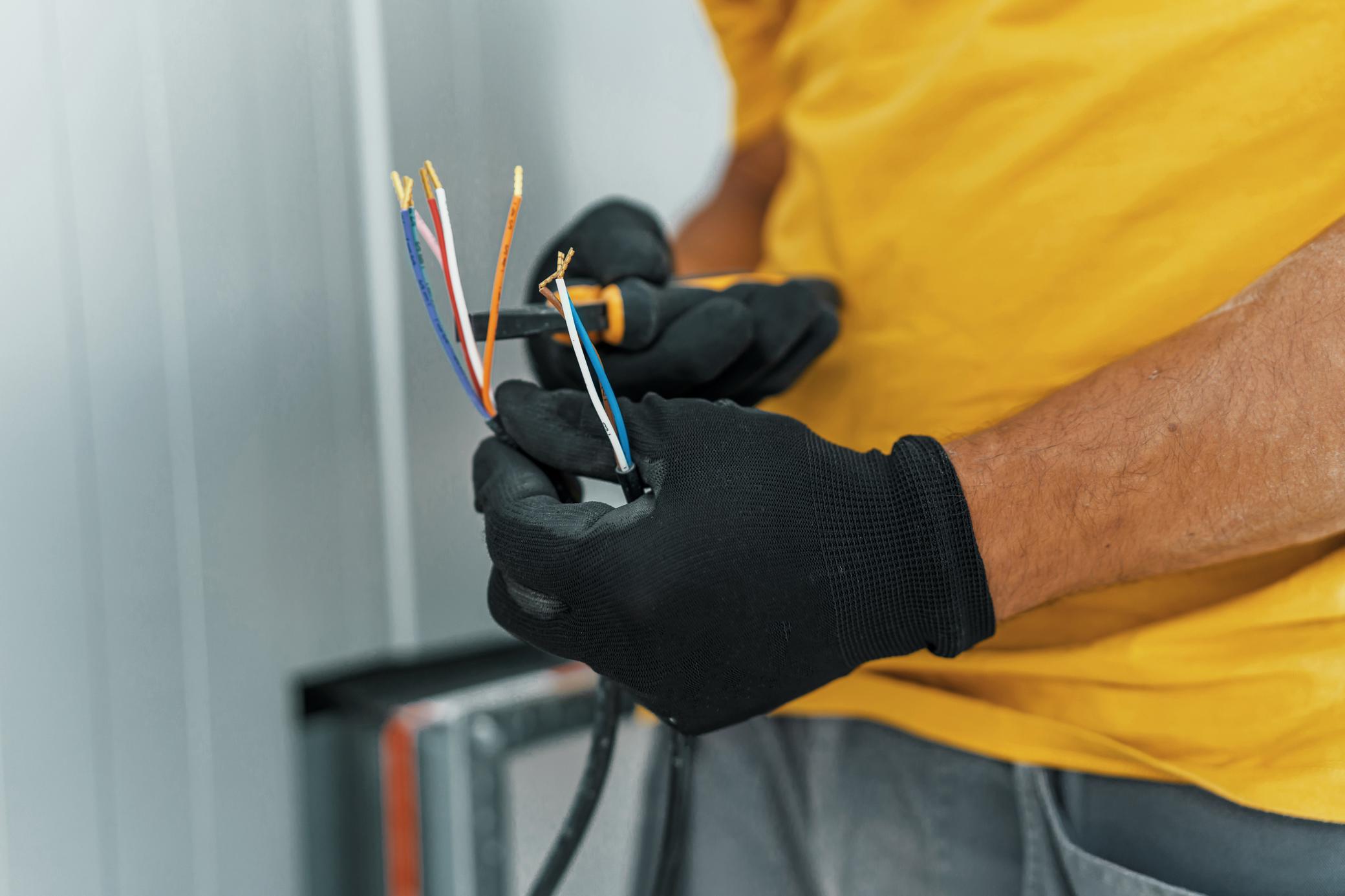 Elektriker schneidet ein elektrisches Kabel zu