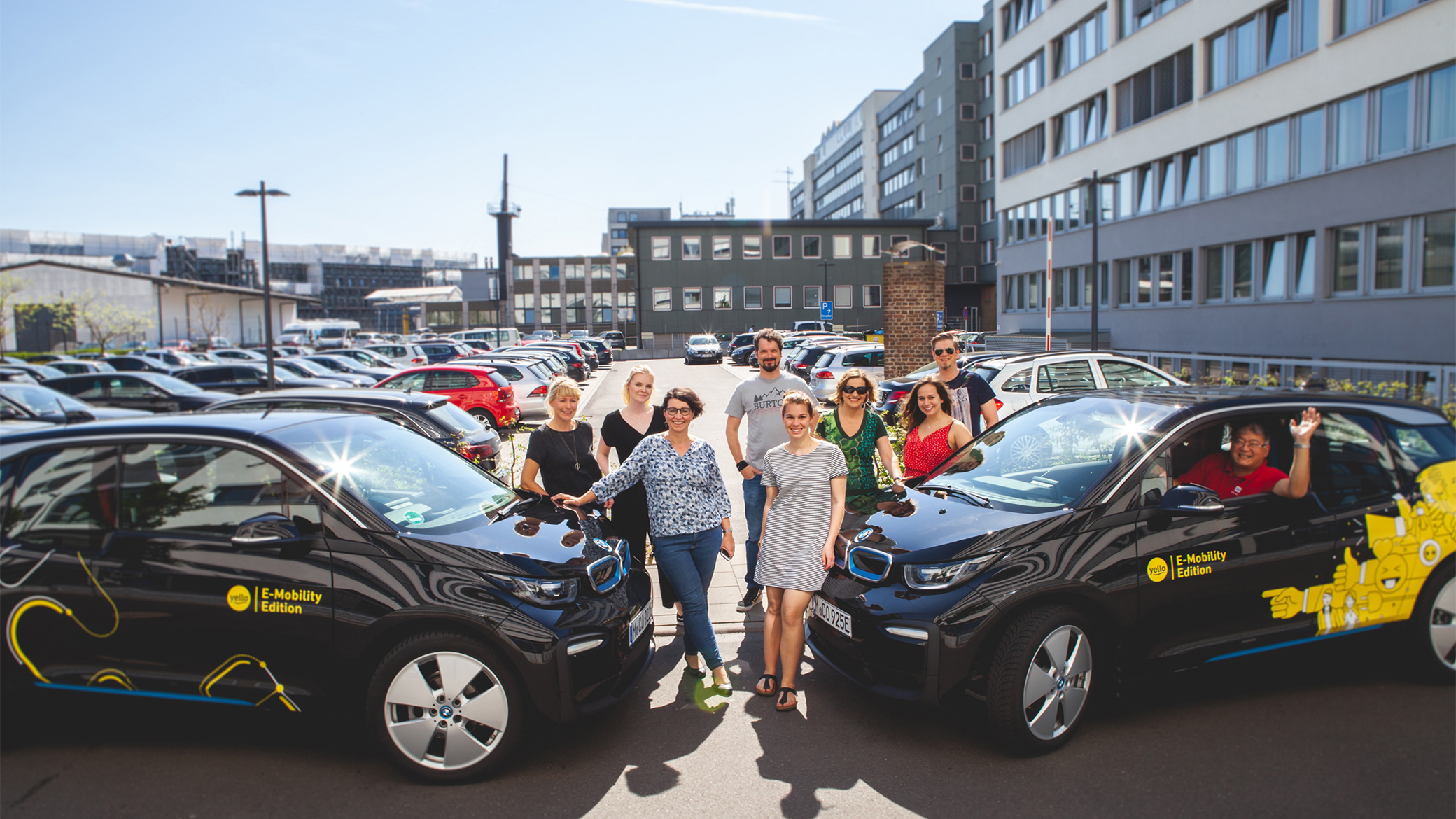 Yello Mitarbeiter mit den neuen BMW i3 im Yello Design