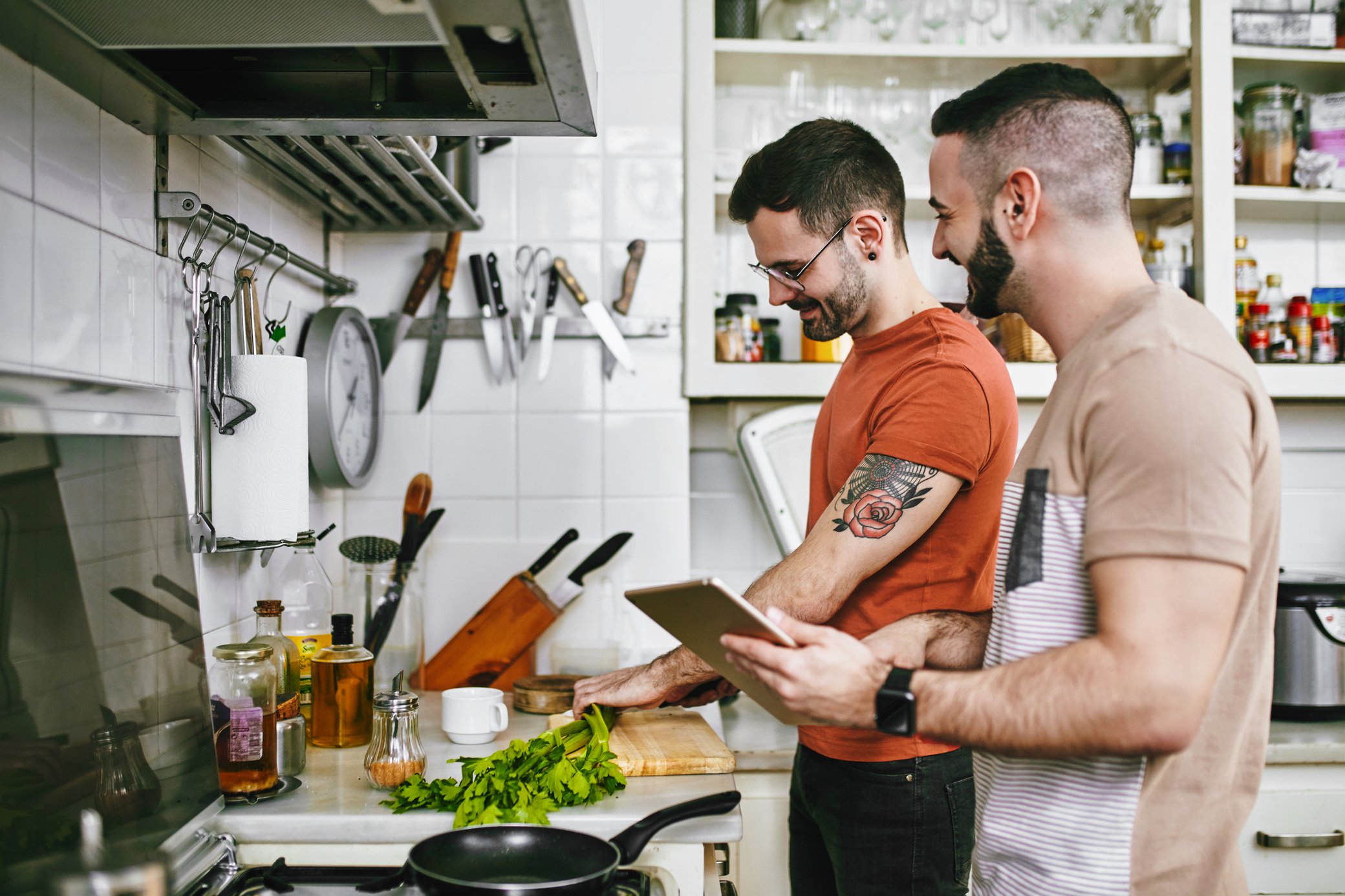 Zwei Männer beim gemeinsamen Kochen mit Tablet in der Küche