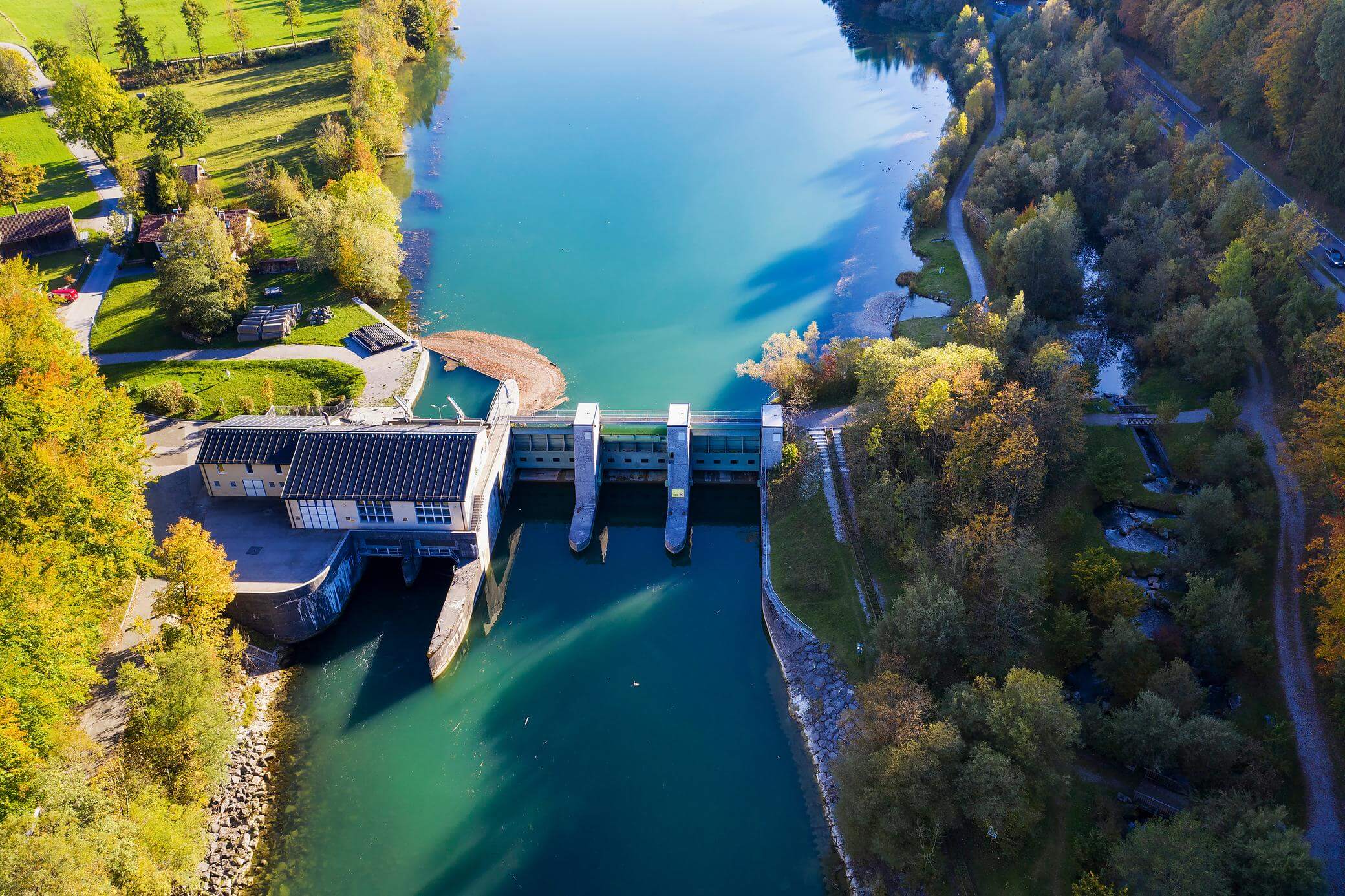 Wasserkraftwerk in Bayern von oben mit grünem Fluß Isar und Bäumen am Ufer